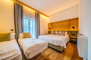 a hotel room with two beds and a window at Hotel Bel Sit Spa in Valle di Cadore +108 photos