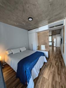 a bedroom with a large bed and a wooden floor at Canela Loft Rosario in Rosario