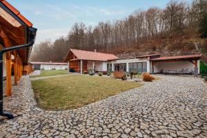 a house with a stone driveway next to a building at Chalupa u Rašovských in Jasenice
