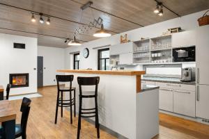 a kitchen with a bar with stools and a fireplace at Chalupa u Rašovských in Jasenice +14 photos