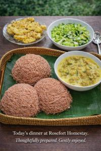 a table topped with plates of food and bowls of food at Rose Fort Homestay in Jaffna