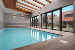 a swimming pool in a house with windows at Chalupa u Rašovských in Jasenice