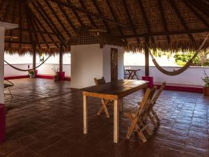 a wooden table and chairs in a room at Casa Porta Rosa in Brisas de Zicatela