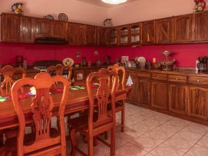 a kitchen with a wooden table and wooden cabinets at Casa Porta Rosa in Brisas de Zicatela