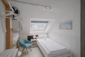 a small room with a bed and a blue chair at Hamburg Sleep Club in Hamburg +16 photos