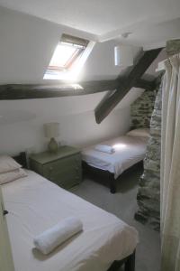 ein Schlafzimmer mit zwei Betten in einem Zimmer mit Fenster in der Unterkunft Welsh Hideaways in Pentre-briwnant