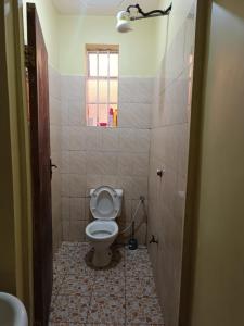 a small bathroom with a toilet and a window at Venguest Homes & Accomodation in Naivasha