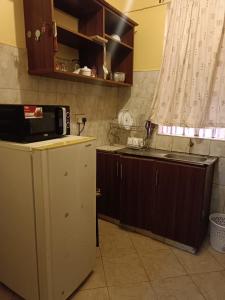 a kitchen with a microwave on top of a refrigerator at Venguest Homes & Accomodation in Naivasha