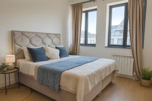 a bedroom with a large bed with blue pillows at Belgrade Waterfront - River Residences in Belgrade