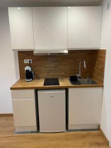a kitchen with white cabinets and a sink at Studio avec toutes les commodités autour in Faverges
