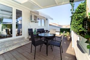 a patio with a table and chairs on a balcony at Refúgio do Pilar in Vila Nova de Gaia