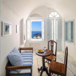a living room with a table and chairs and a window at Aigialos Luxury Traditional Settlement in Fira