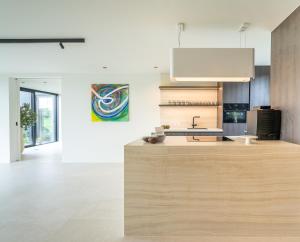 a kitchen with a wooden counter and a sink at Oase 41 - 5 STAR location with Indoor swimming pool & unique landscape view in Sint-Laureins