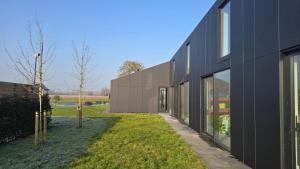 an external view of a black building at Oase 41 - 5 STAR location with Indoor swimming pool & unique landscape view in Sint-Laureins
