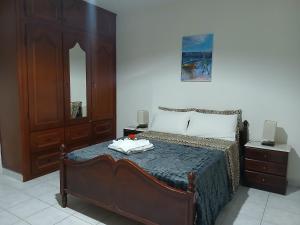 a bedroom with a bed with a dresser and a mirror at ROMANA guest house in Tarrafal da Vila de Ribeira Grande