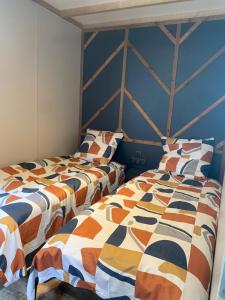 two beds sitting next to each other in a room at Les cottages du Tremble in Ruffec