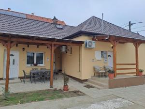 a house with a pavilion with a table and chairs at Emma Apartman 2 in Vecsés