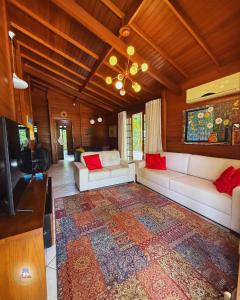 a living room with a couch and a tv at EcoVibe House Florianópolis in Florianópolis