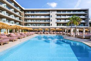 a swimming pool with lounge chairs and a hotel at Aubamar Palma Resort in Playa de Palma