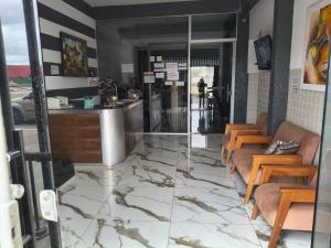 a restaurant with a lobby with chairs and a counter at Hotel Lm in Pedro Canário