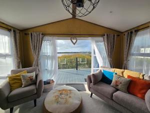 a living room with two couches and a table at 1 Sunset View in Millom