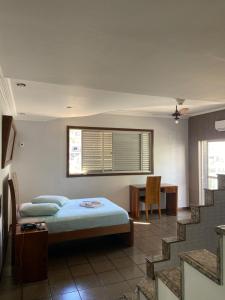 a bedroom with a bed and a table and stairs at Garden Hotel in Nova Era