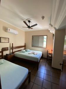 a bedroom with two beds and a ceiling fan at Garden Hotel in Nova Era