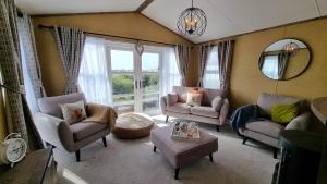 a living room with chairs and a large window at 1 Sunset View in Millom +77 photos