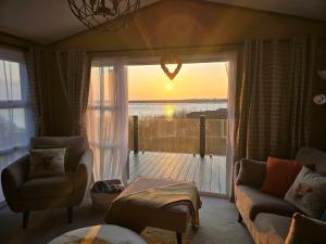 a living room with a couch and a window with the sunset at 1 Sunset View in Millom