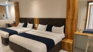 a hotel room with two beds and a television at Hotel Ravi Palace Agra in Agra +64 photos