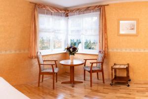 a room with a table and two chairs and a window at Hotel Waldhaus Waltershausen in Waltershausen