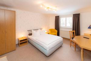 a hotel room with a bed and a desk at Hotel Waldhaus Waltershausen in Waltershausen +11 photos