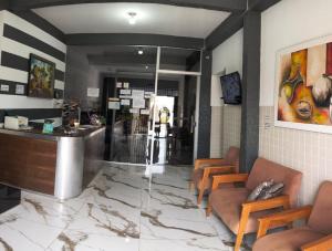 a bar in a restaurant with chairs and a counter at Hotel Lm in Pedro Canário