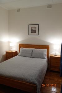 傑維斯角的住宿－Morella Farmstay，一间卧室配有一张带2个床头柜和2盏灯的床。