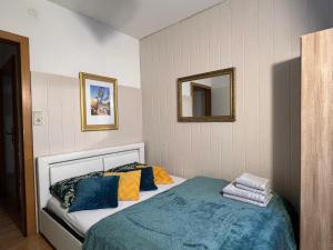 a bedroom with a bed with blue and yellow pillows at Hotel Zemlinski in Payerbach