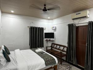 a bedroom with a bed and a chair and a tv at Seaway inn guesthouse in Baga +48 photos