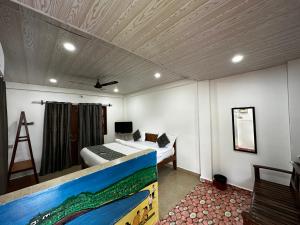 a bedroom with a bed with a painting on the ceiling at Seaway inn guesthouse in Baga