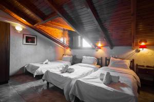 a group of four beds in a room at Hotel Villa Apollonia Delphi in Delphi
