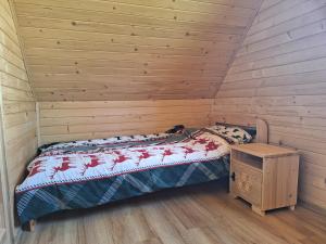 a bedroom with a bed and a wooden wall at Góralska Przystań in Nowa Wieś