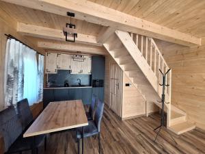 a dining room with a wooden table and a staircase at Góralska Przystań in Nowa Wieś