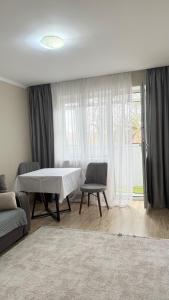 a living room with a table and chairs and a window at ИП.МЕДИНА in Taraz