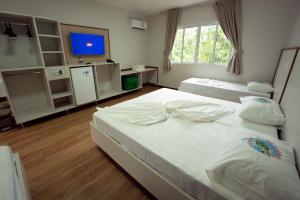a bedroom with two beds and a tv in it at Ody Park Resort Hotel in Iguaraçu