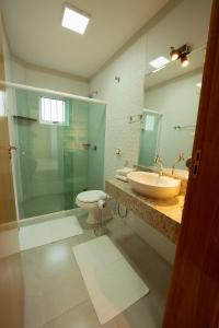 a bathroom with a glass shower and a toilet and a sink at Ody Park Resort Hotel in Iguaraçu +91 photos