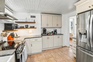 a kitchen with white cabinets and a stainless steel refrigerator at Beaufort 308 Charles in Beaufort