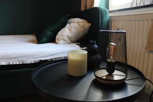 a black table with a lamp and a bed at Design Apartment in Plettenberg