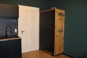 a kitchen with a black refrigerator and a white door at Design Apartment in Plettenberg +14 photos