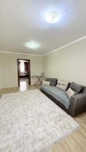 a living room with a couch and a rug at ИП.МЕДИНА in Taraz