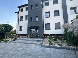 a large white building with a courtyard in front of it at Apartament z widokiem 3 in Chełm
