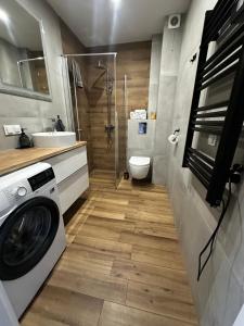 a bathroom with a washing machine and a sink at Apartament z widokiem 3 in Chełm +7 photos