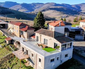 an aerial view of a house with mountains in the background at Gîte du Vieux Cuvage in Vaux-en-Beaujolais